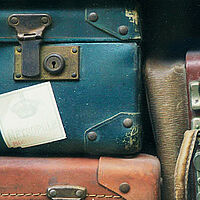 pile of old fashioned leather suitcase with travel stamps on them 